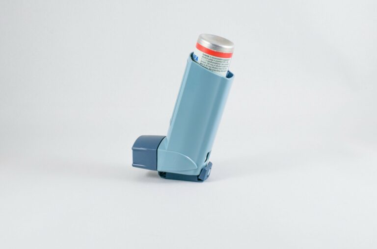 Blauer Inhalator mit grauem Deckel, auf einem hellen Hintergrund, zur Anwendung bei Atemwegserkrankungen.