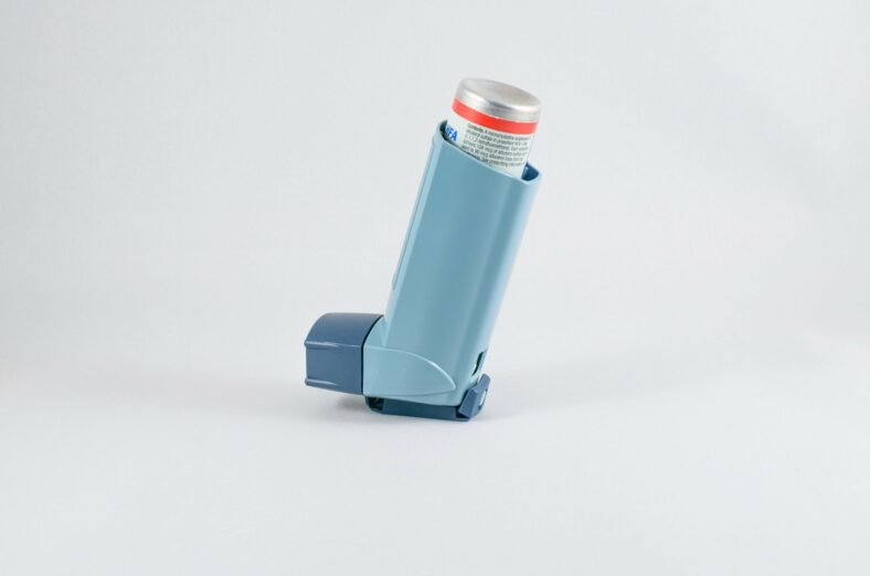 Blauer Inhalator mit grauem Deckel, auf einem hellen Hintergrund, zur Anwendung bei Atemwegserkrankungen.
