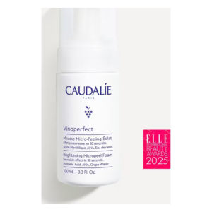 Flasche mit Micro-Peeling-Schaum von CAUDALIE, weiß mit blauen Schriftzügen, 100 ml, dekoriert mit Auszeichnungssiegel.