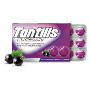 Paket mit Tantills Blackcurrant Halspastillen auf lila Hintergrund, umgeben von schwarzen Johannisbeeren und einem frischen Blatt.