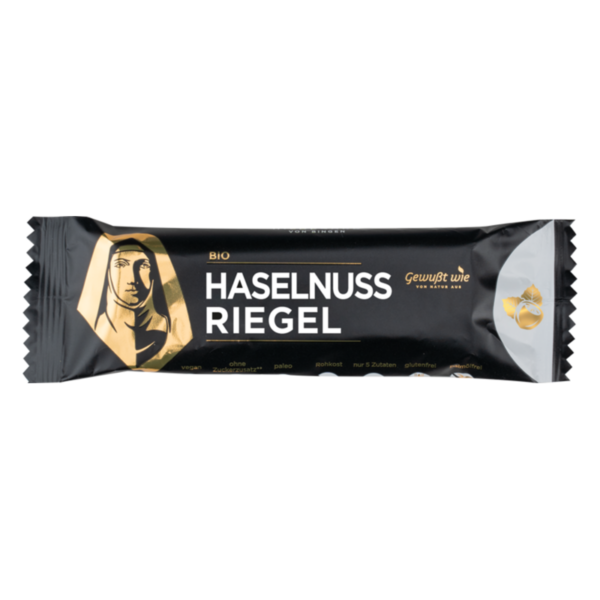 Bio Haselnuss Riegel in schwarzer Verpackung mit goldenen Akzenten und vorne abgebildetem Gesicht einer Nonne.