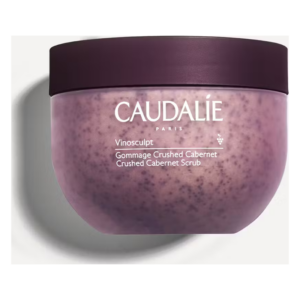 Runde, lila Verpackung des Caudalie Vinosculpt Gommage Crushed Cabernet mit einem dunklen Deckel.