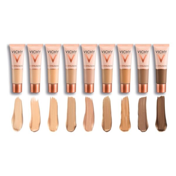 Verschiedene Farbnuancen von Vichy Make-up in Tuben, mit passenden Farbpigmenten auf einem weißen Hintergrund.