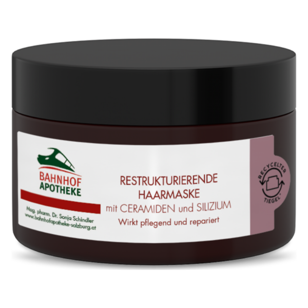 Dunkelbrauner Tiegel mit restrukturierender Haarmaske, beschriftet mit Ceramiden und Silizium, pflegend und reparierend.