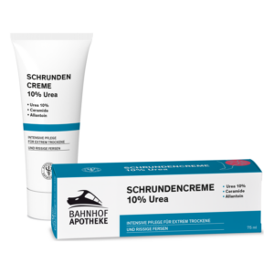 Schrundencreme 10% Urea in einer Weißtube und einer blauen Verpackung, zur Pflege extrem trockener Haut.