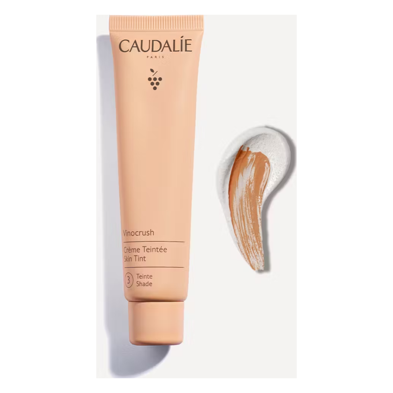 Tube mit Farbtoncreme von Caudalie und einem Streifen der Creme auf Weißem Hintergrund